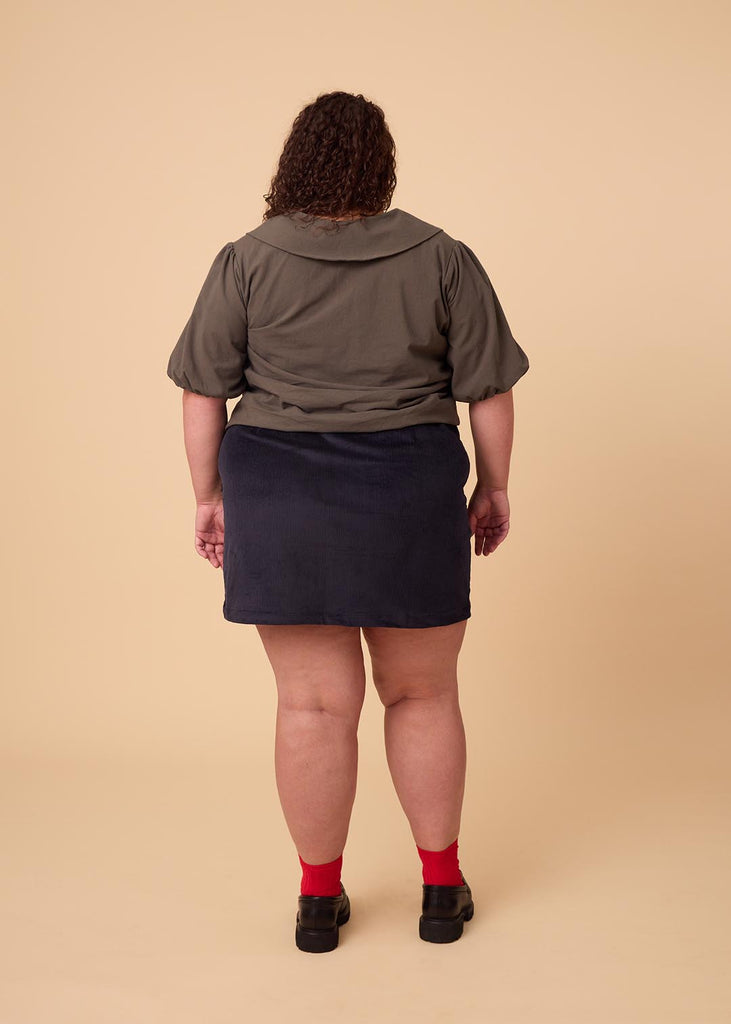 a plus size woman wearing a navy miniskirt