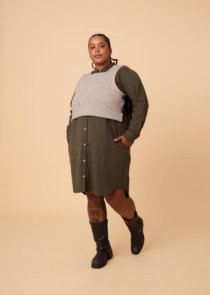 a plus size woman wearing a grey wool vest