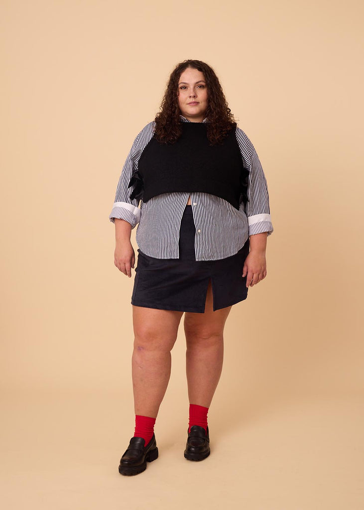 a plus size woman wearing a navy miniskirt