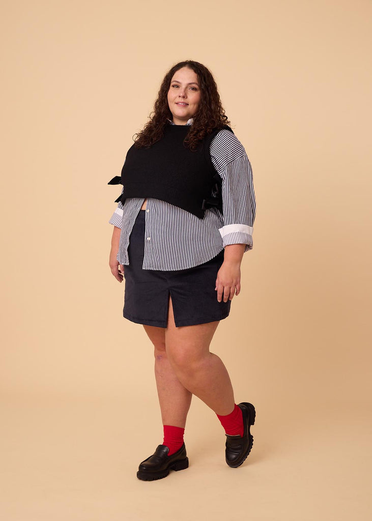 a plus size woman wearing a black wool vest