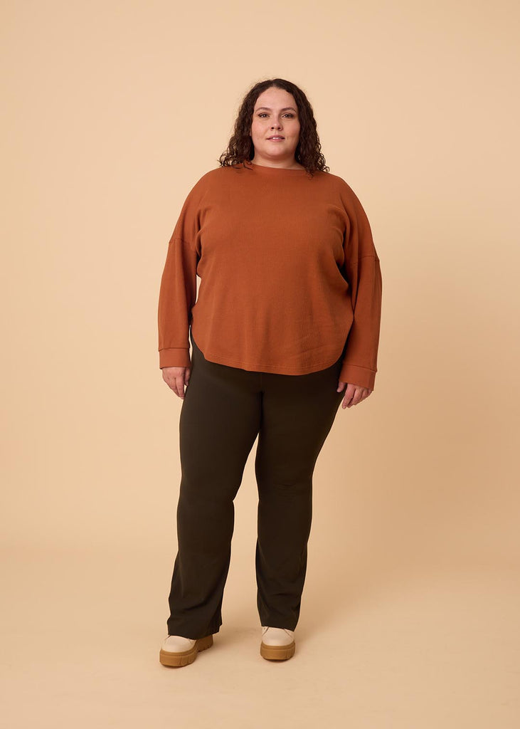 plus size woman wearing orange long sleeve waffle top