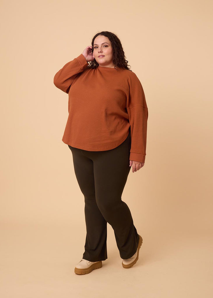 plus size woman wearing orange long sleeve waffle top