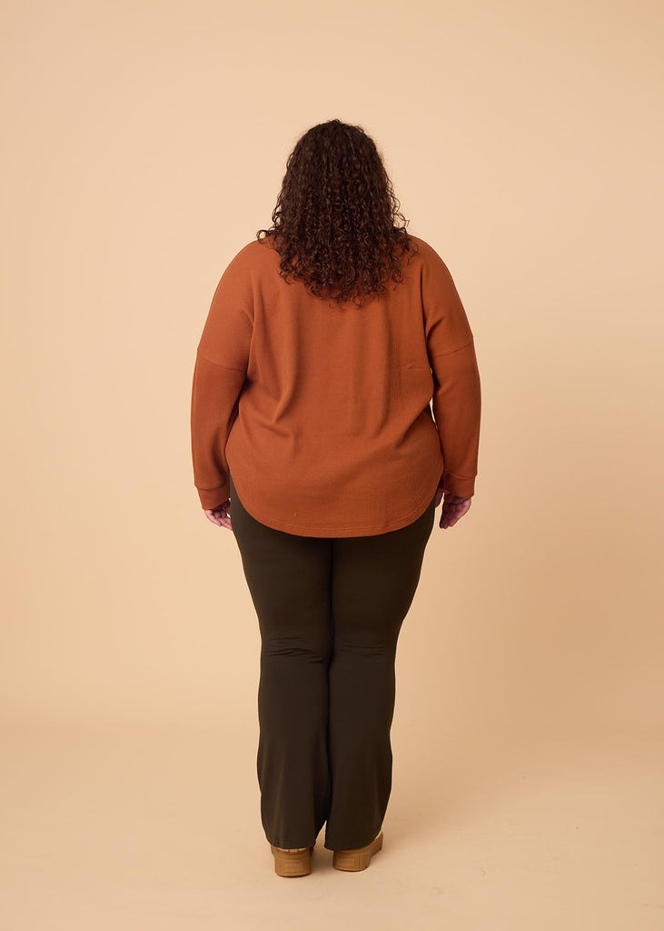 plus size woman wearing orange long sleeve waffle top