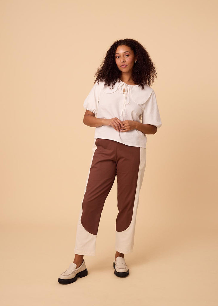 a straight sized woman wearing brown and white pants