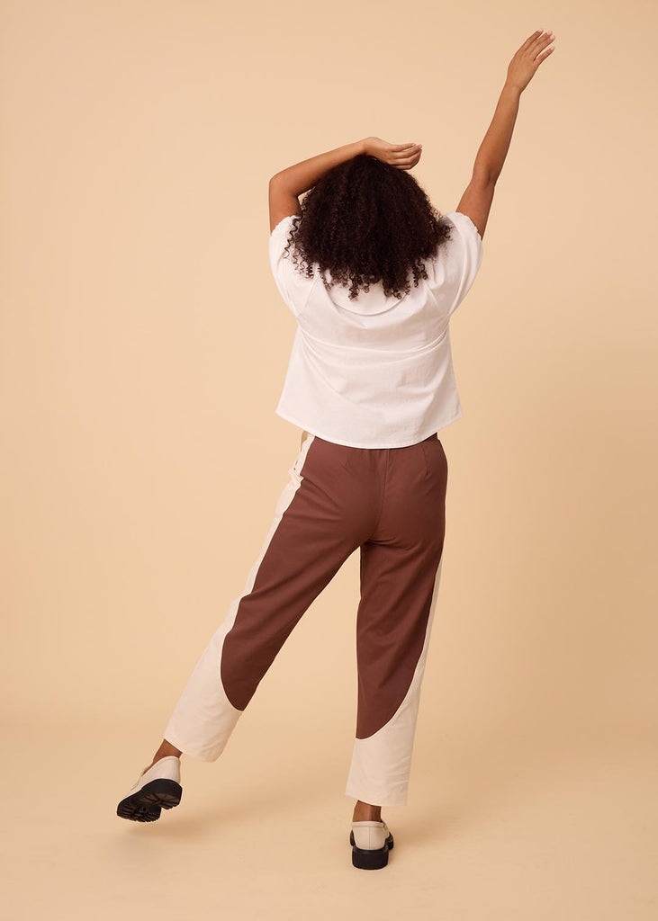 a straight size woman wearing a white blouse with an exaggerated collar