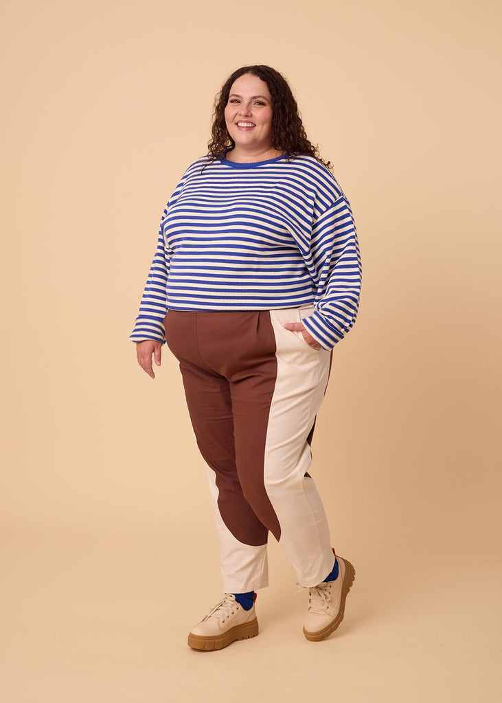 a plus sized woman wearing brown and white pants