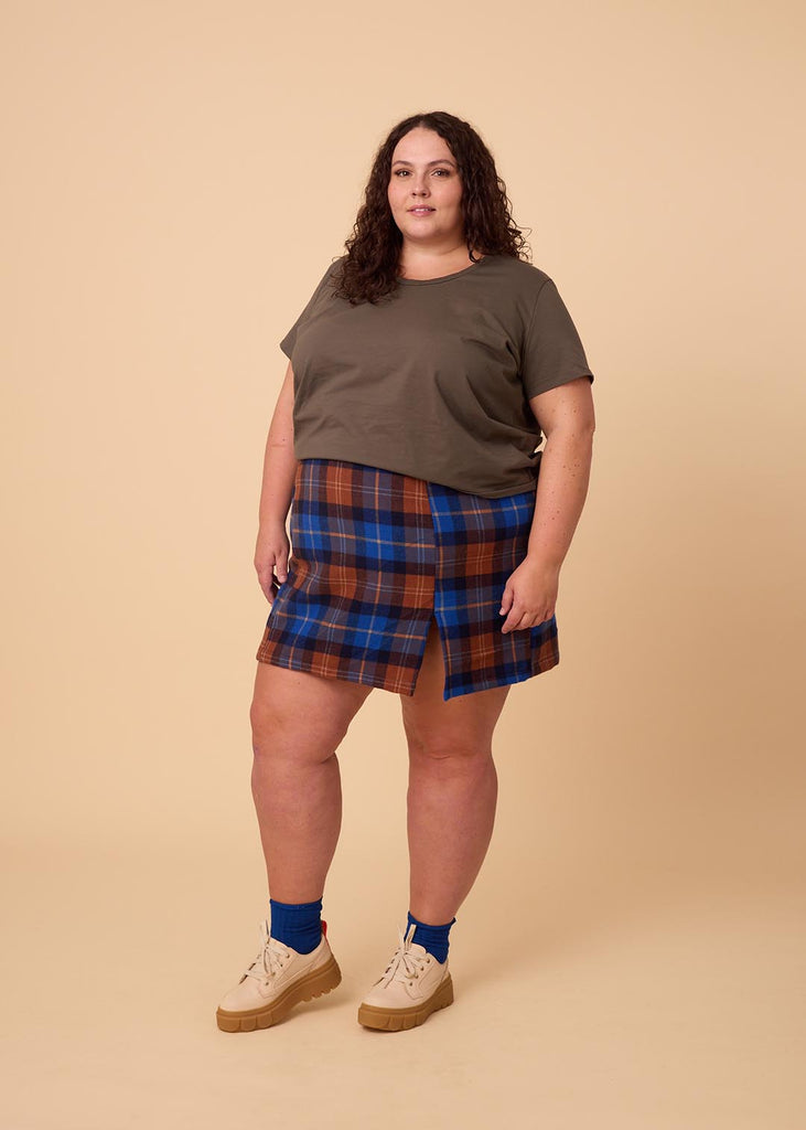 a close up of a plus sized woman wearing a plaid miniskirt