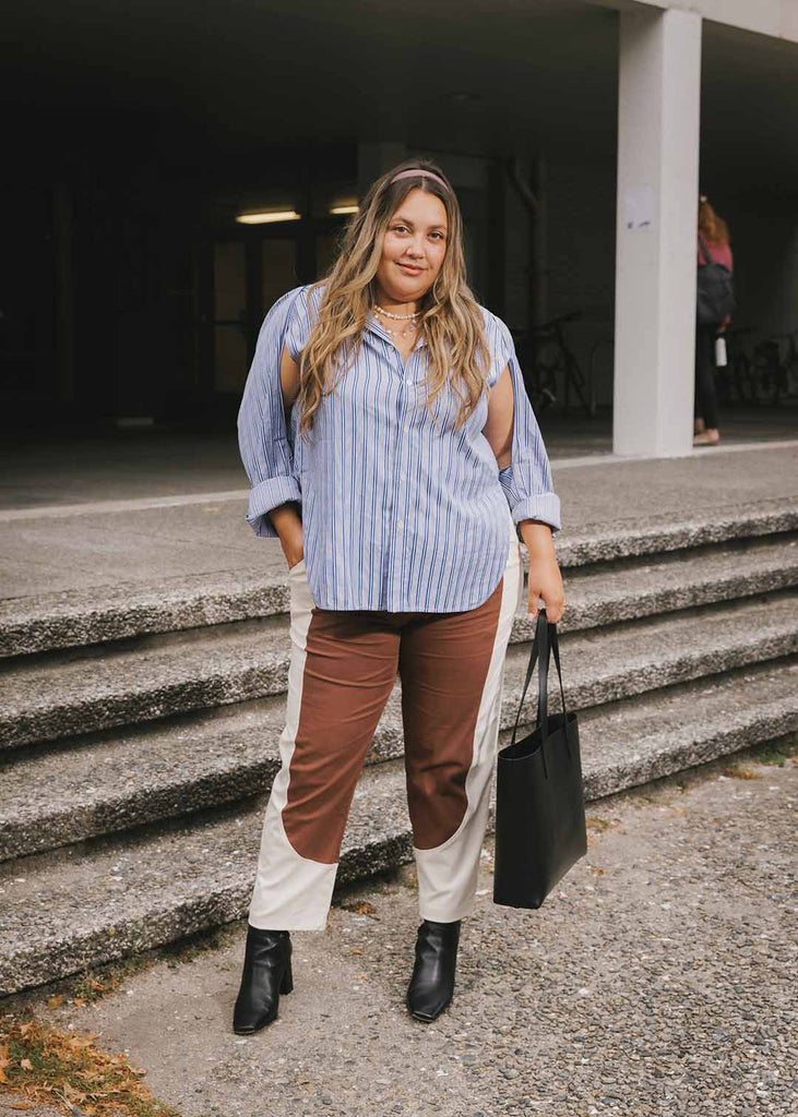 a plus sized woman wearing brown and white pants