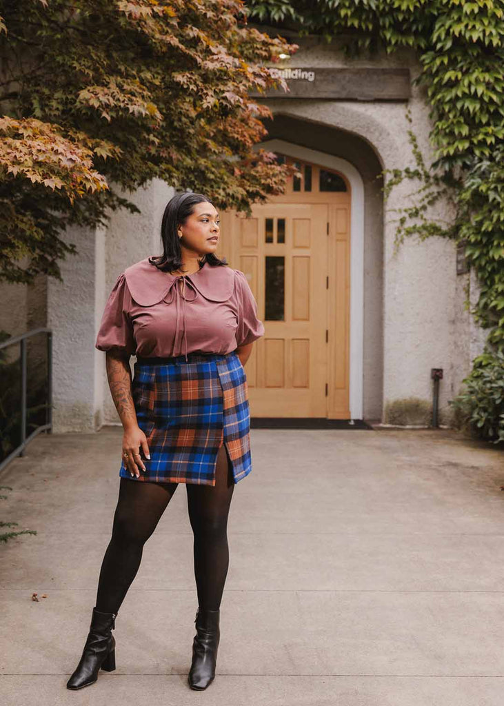 a plus sized woman wearing a plaid miniskirt