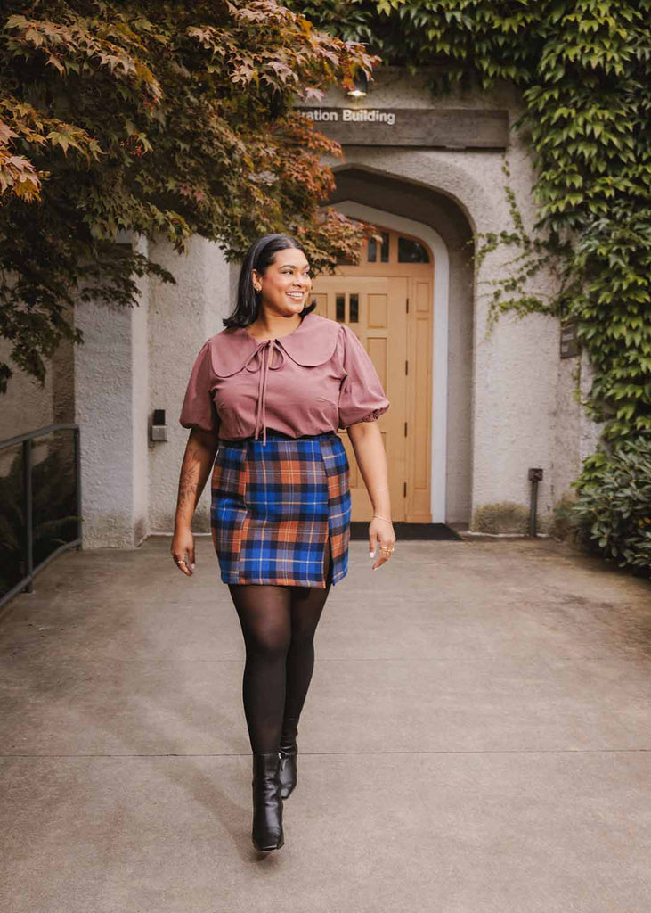 a close up of a plus sized woman wearing a plaid miniskirt