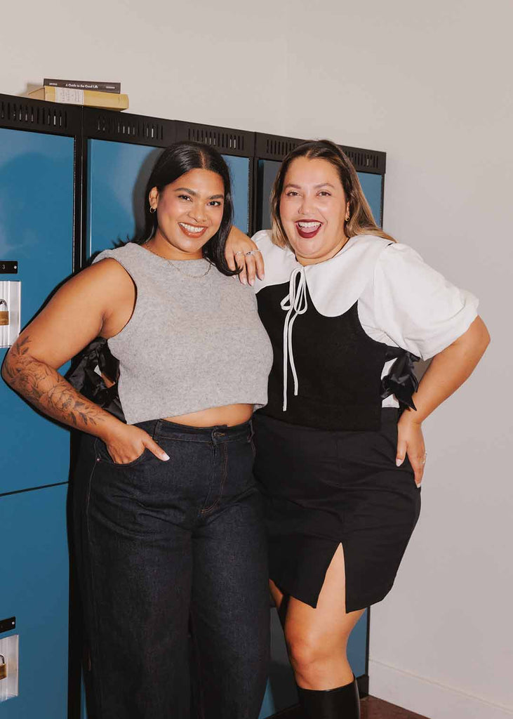 two woman posing in matching wool vests