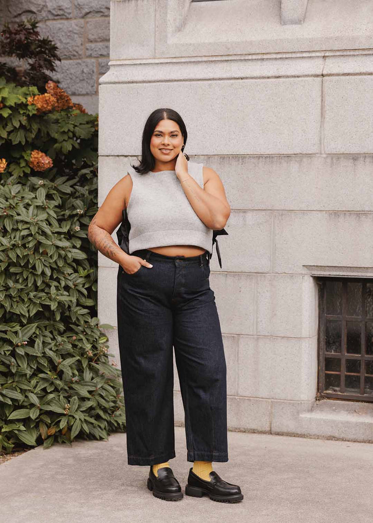 a plus size woman wearing a grey wool vest