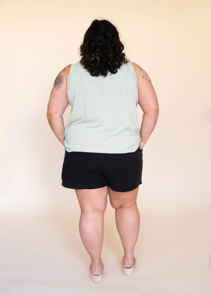 a plus size woman wearing a sage tank top