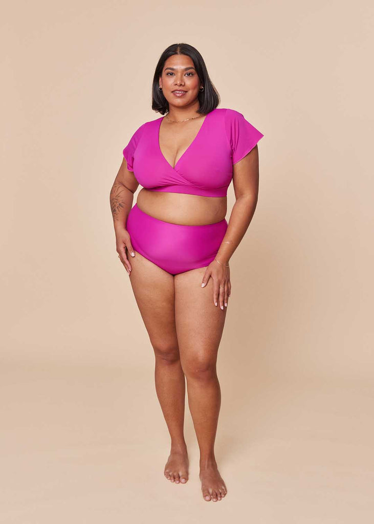 a midsize woman wearing a pink two piece swimsuit