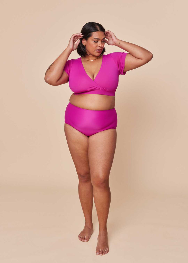 a midsize woman wearing a pink two piece swimsuit