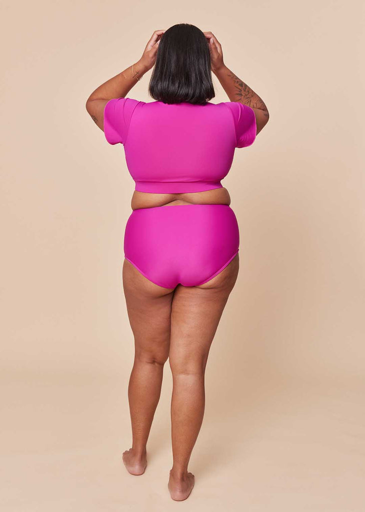 a midsize woman wearing a pink two piece swimsuit