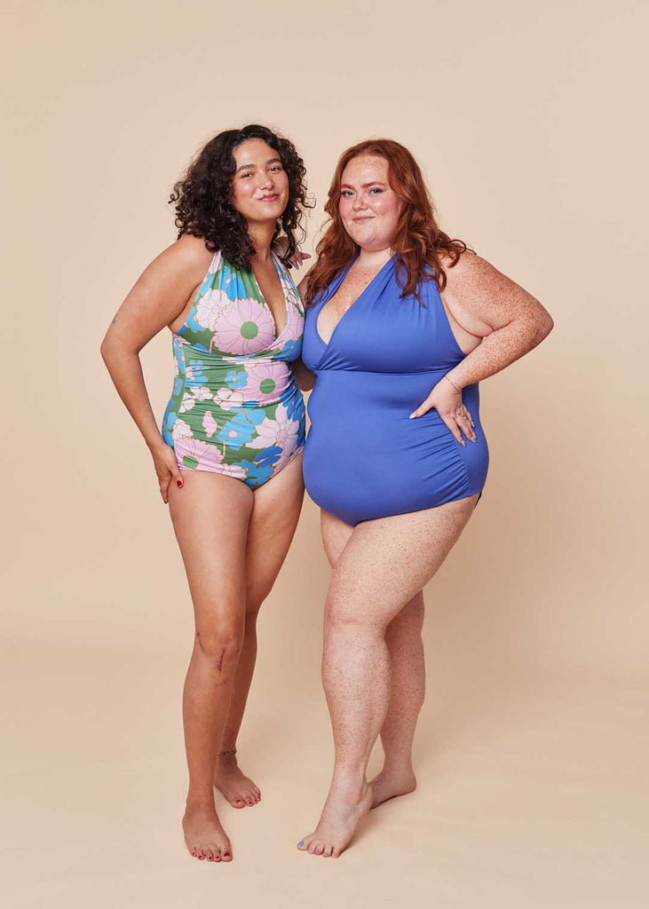 two woman wearing matching one piece swimsuits