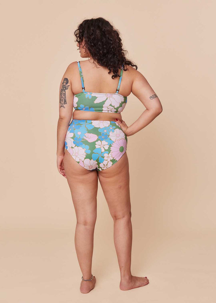 a mid size person in a floral two piece bathing suit