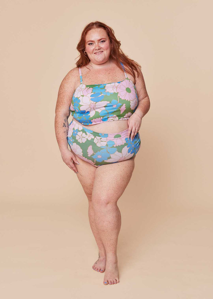 a plus size woman wearing a floral two piece swimsuit