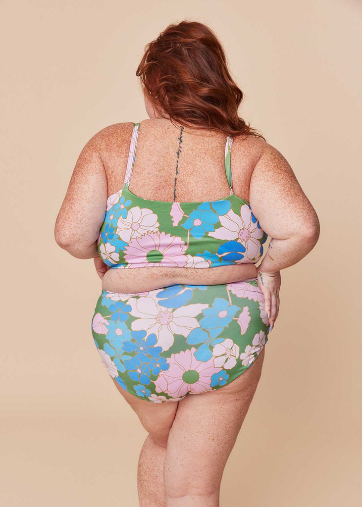 a plus size woman wearing a floral two piece swimsuit