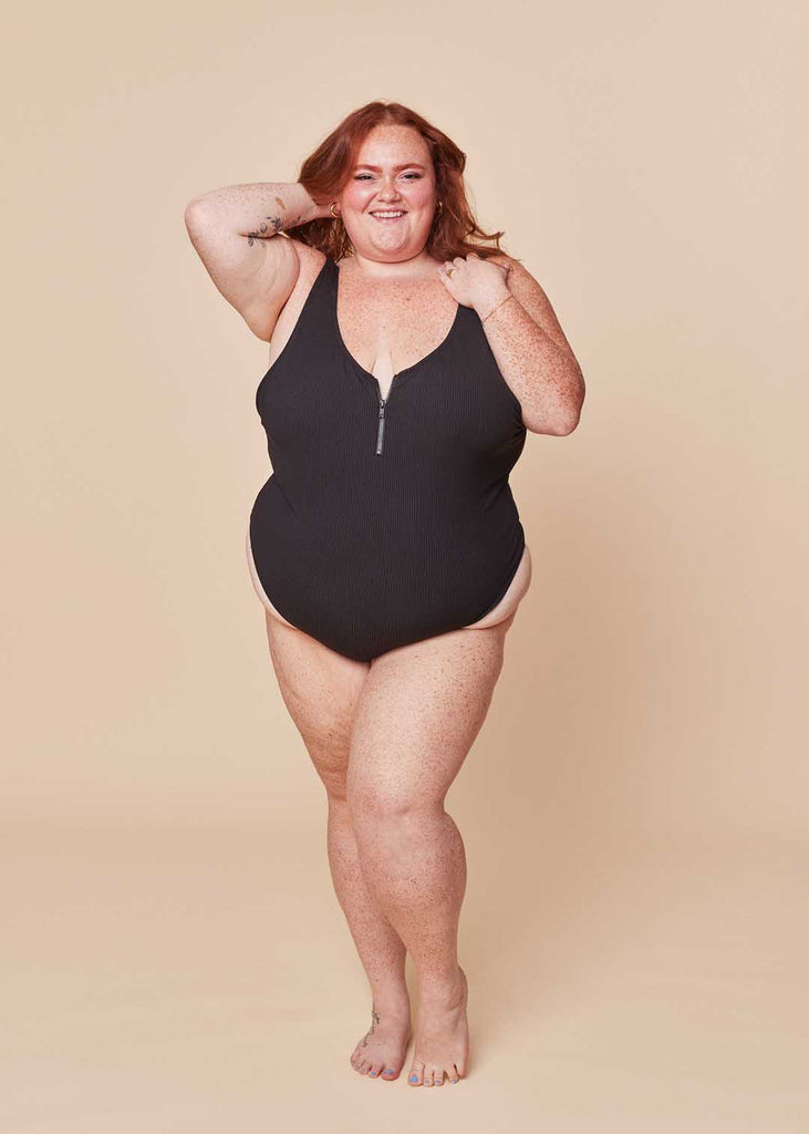 a plue size woman in a black one piece swimsuit