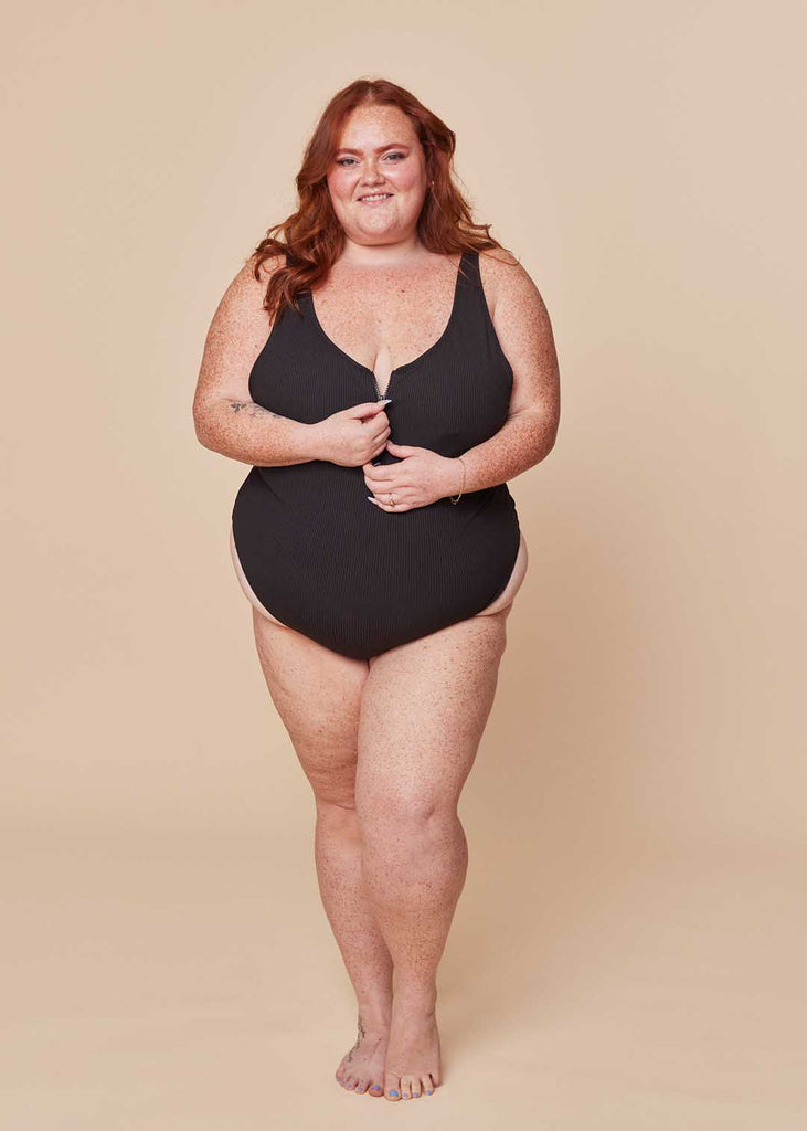 a plus size woman in a black one piece swimsuit