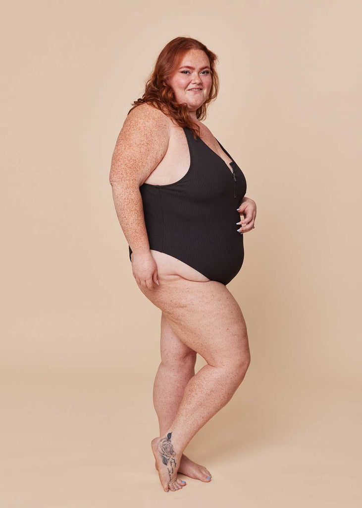 a plus size woman in a black one piece swimsuit