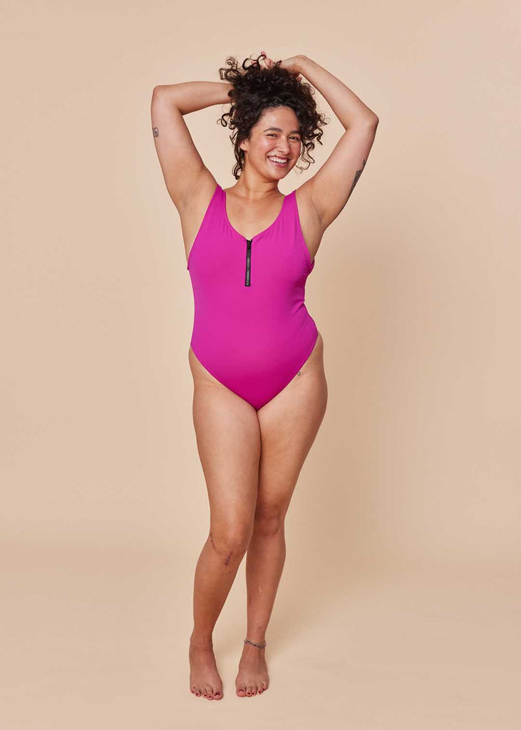 a straight size woman in a pink one piece swimsuit