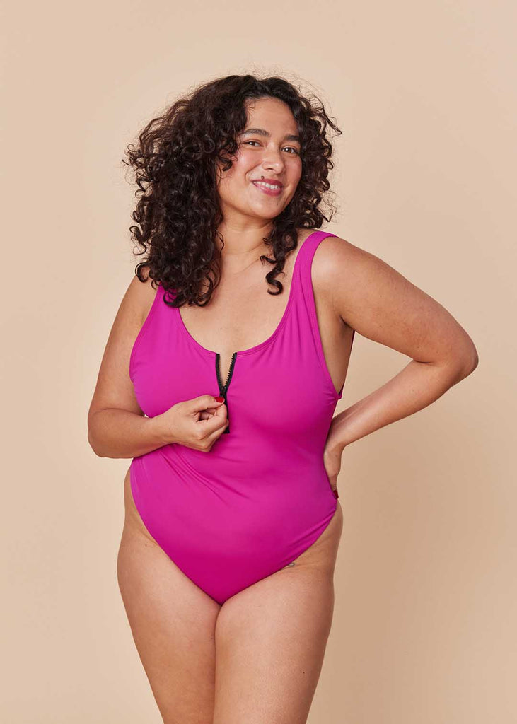 a straight size woman in a pink one piece swimsuit