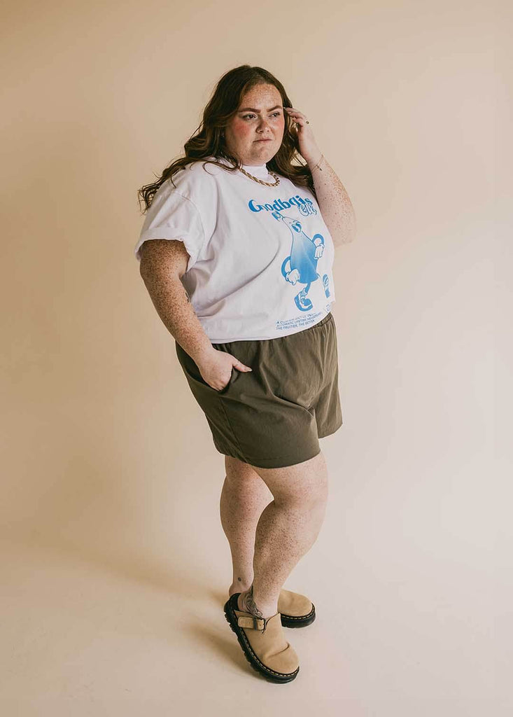 a plus size woman wearing olive green shorts