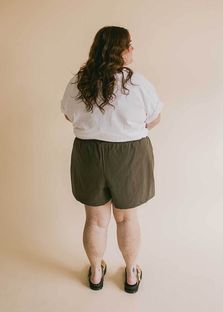 a plus size woman wearing olive green shorts