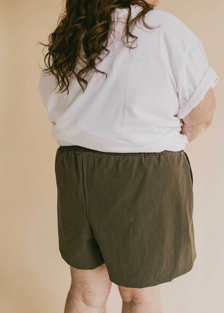 a close up of a plus woman size wearing olive green shorts