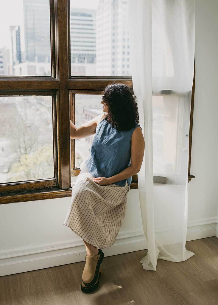 a mid size woman wearing a blue tank top