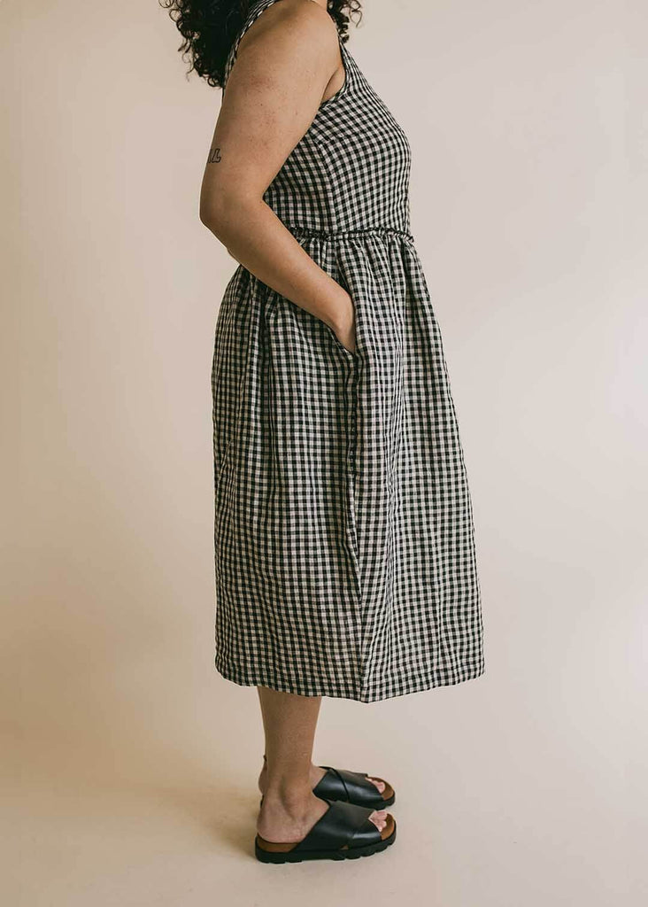 a midsize woman wearing a gingham sundress