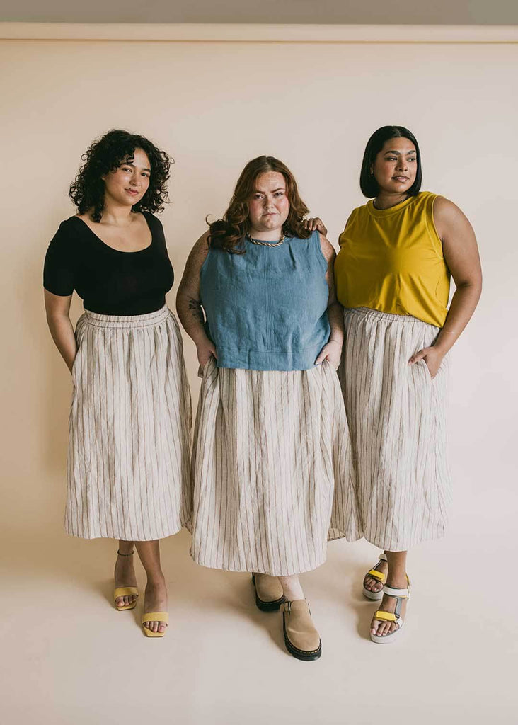 a trio of women wearing striped midi skirts