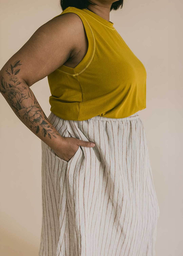a close up of a mid size woman wearing a striped midi skirt