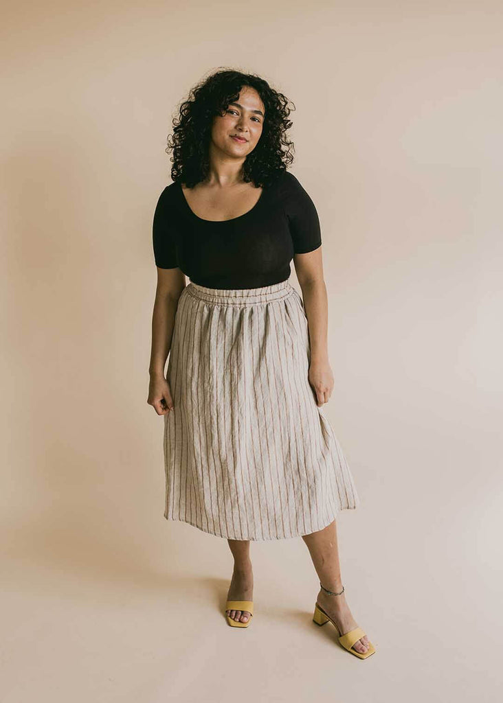 a mid size woman wearing a striped midi skirt