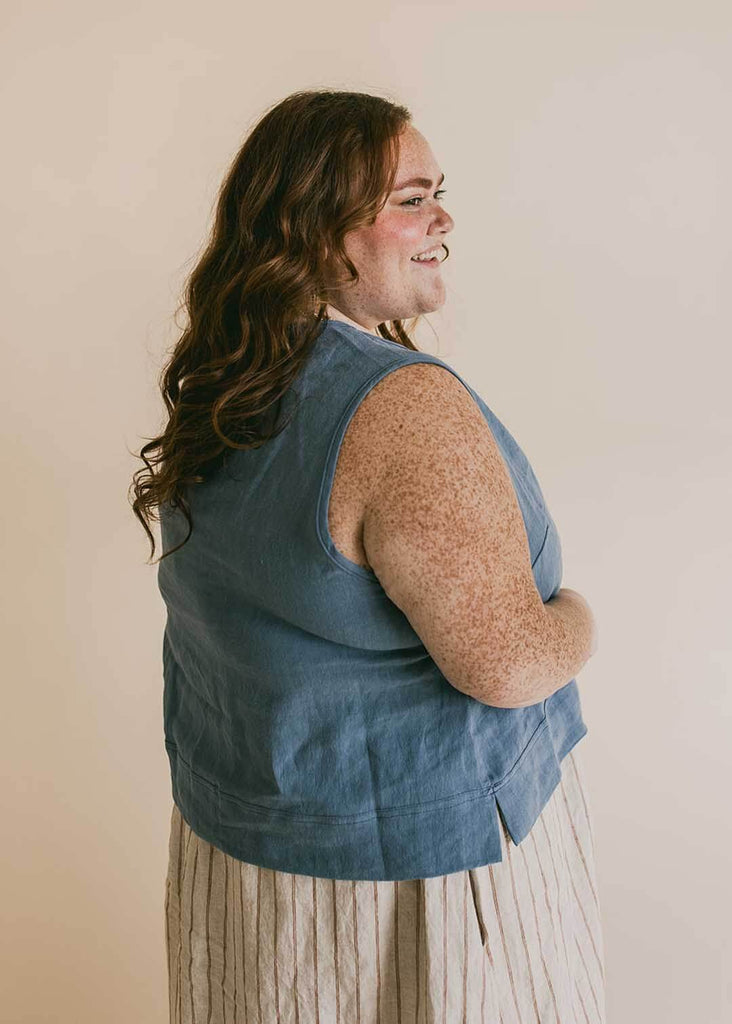 a plus size woman wearing a blue tank top