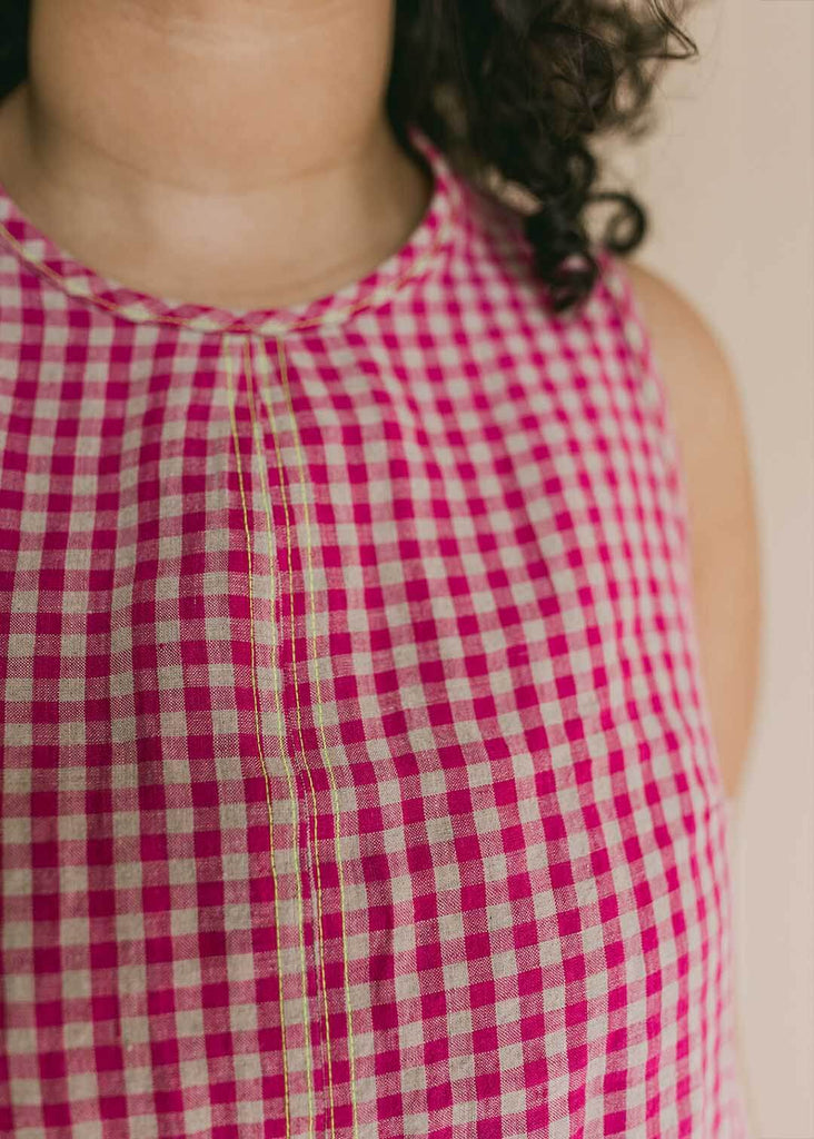 a close up of a mid size woman wearing a red gingham tank top