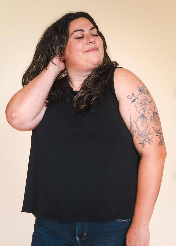 a plus size woman wearing a black tank top