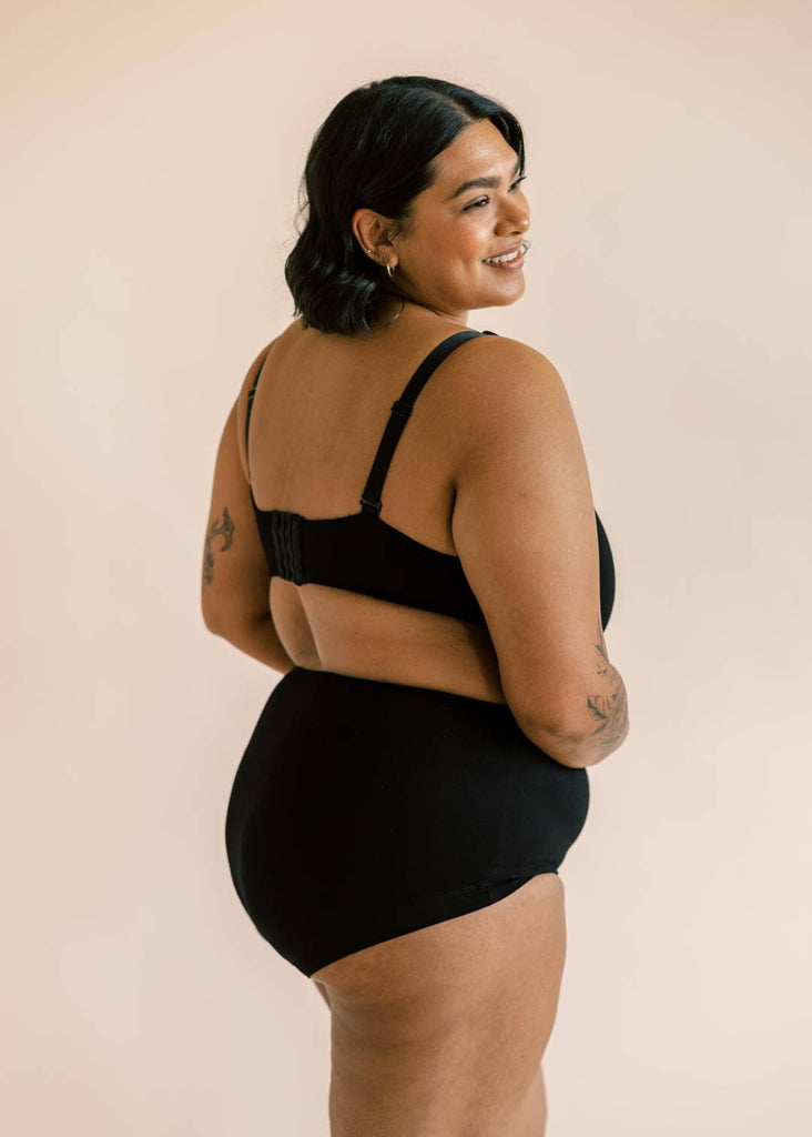 a plus sized woman wearing a black matching bra and underwear set