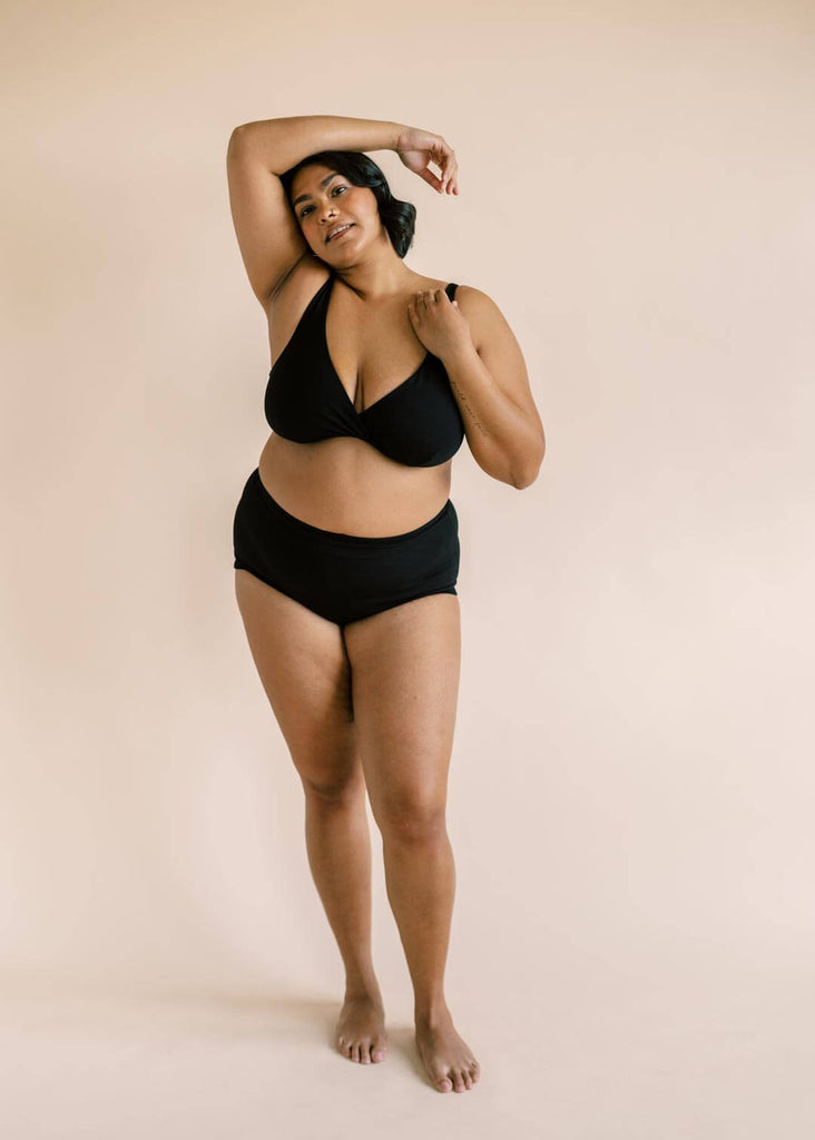 a plus size woman wearing a black bralette