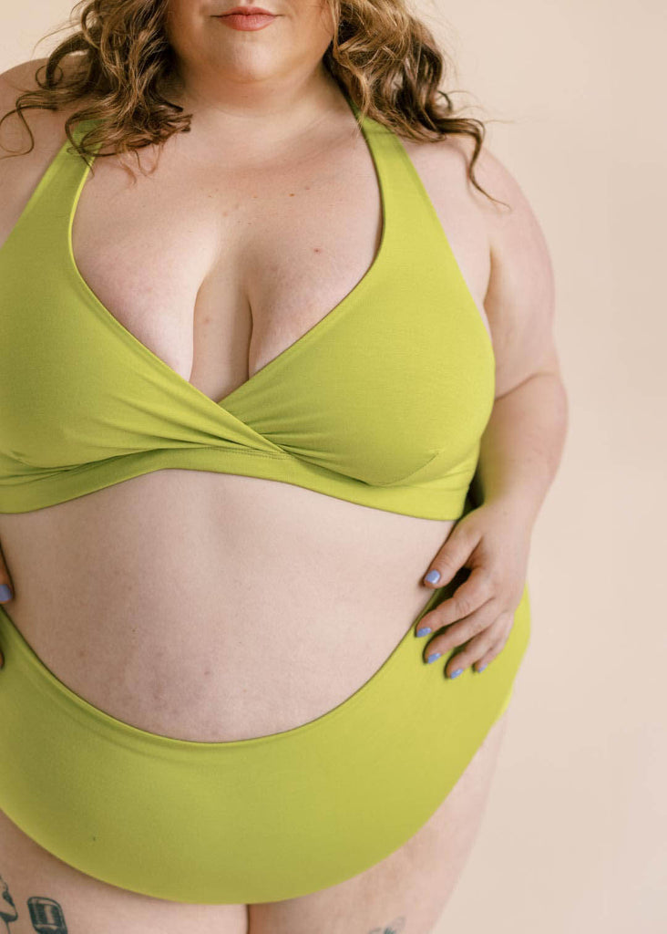 a close up of a plus size woman wearing a green bralette