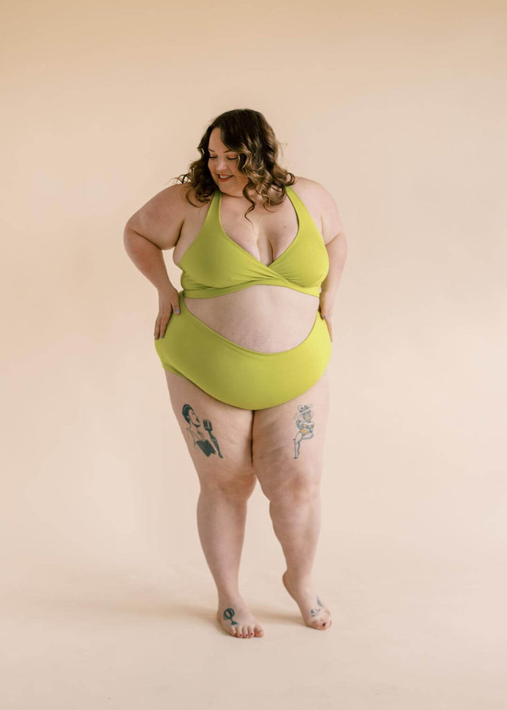 a plus size woman wearing a green bralette