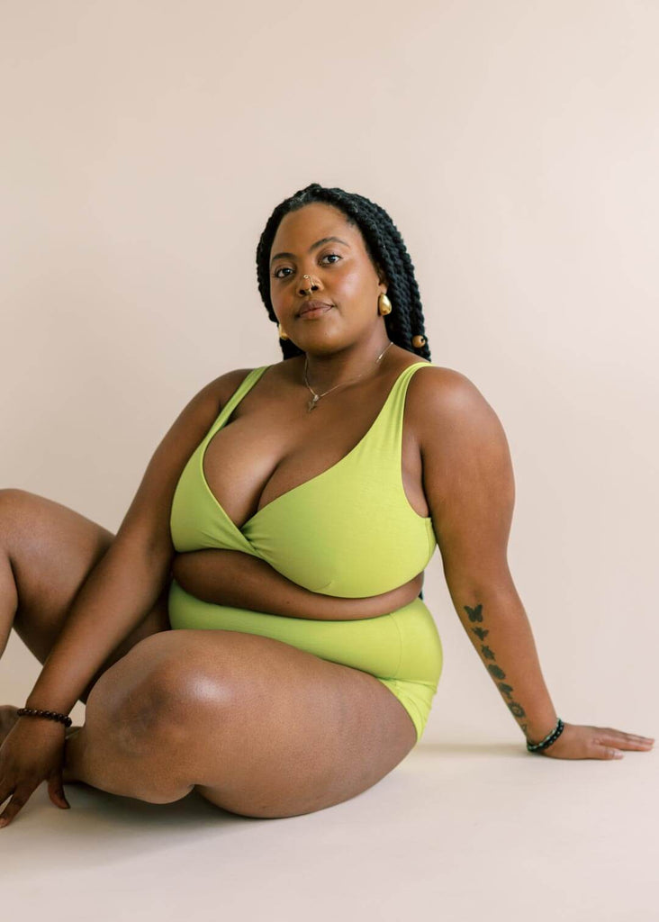 a mid size woman wearing a green bralette