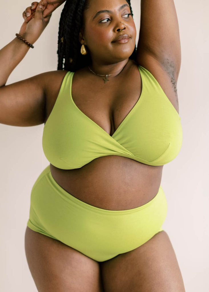 a mid sized woman wearing a green matching bra and underwear set