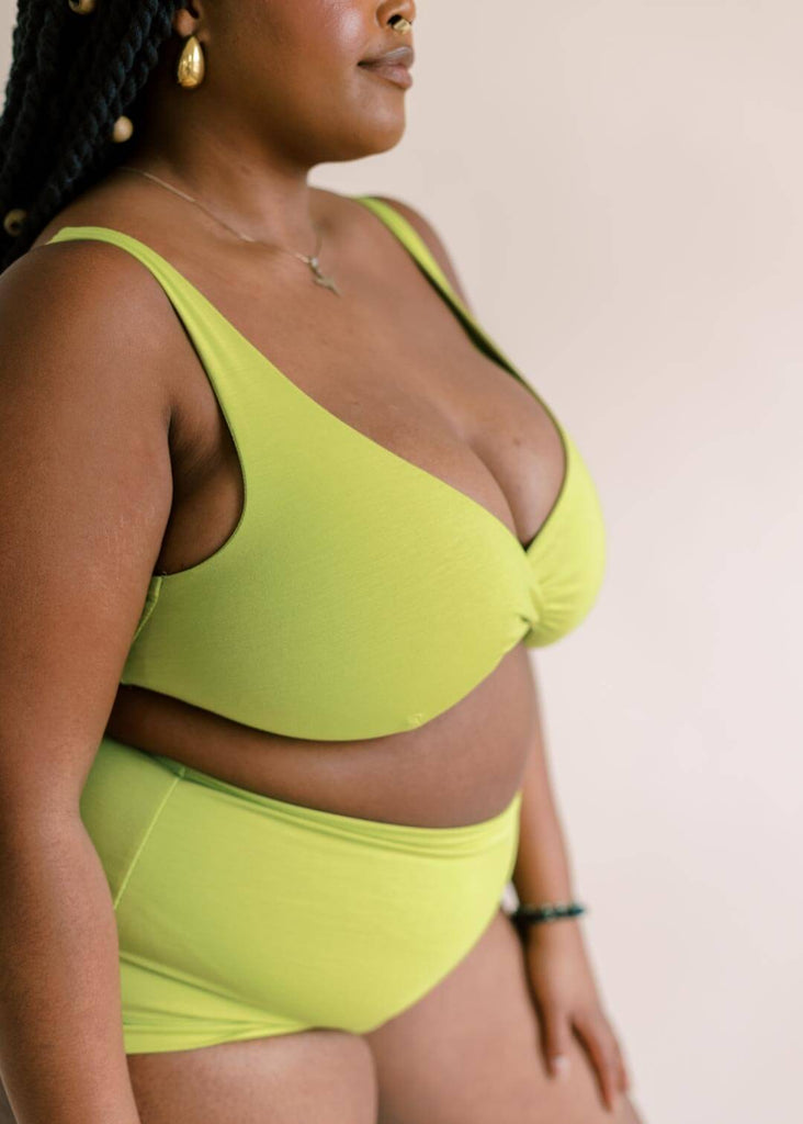 a close up of a mid size woman wearing a green bralette