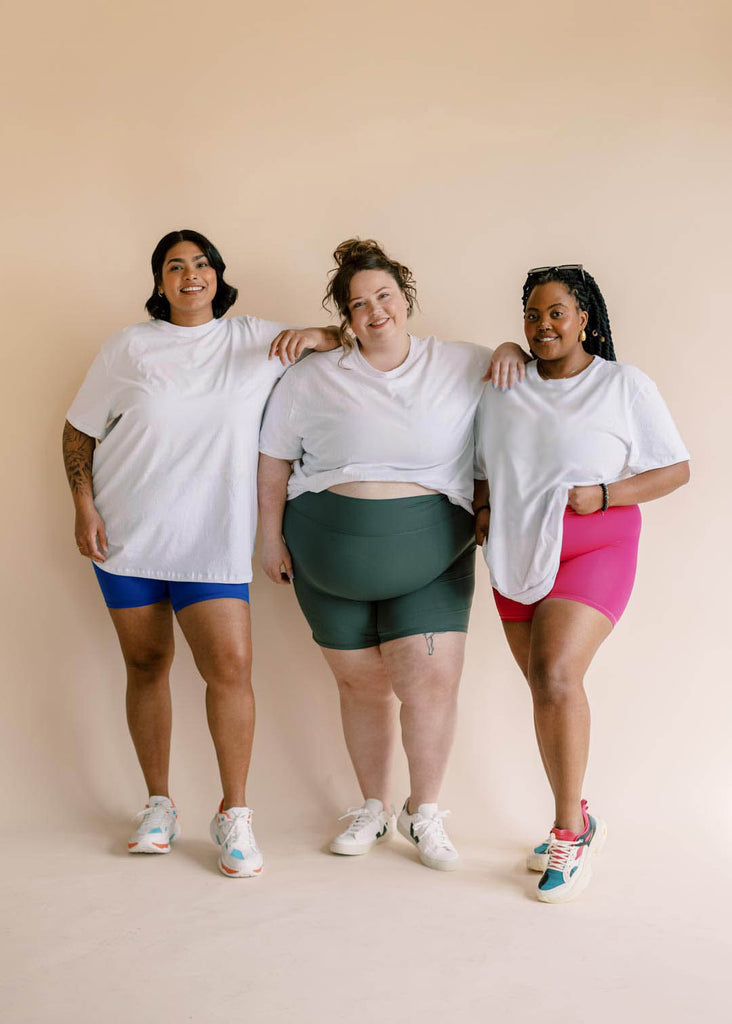 a trio of women in oversized white tees