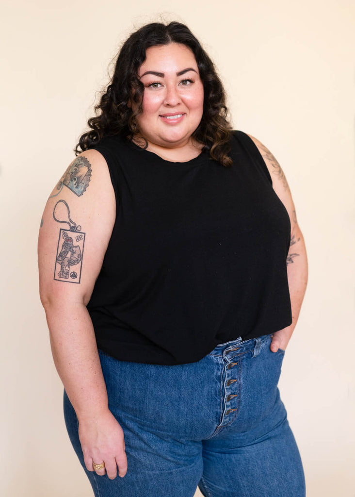 a plus size woman wearing a black tank top