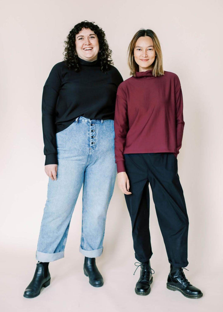 two women wearing roll neck sweatshirts